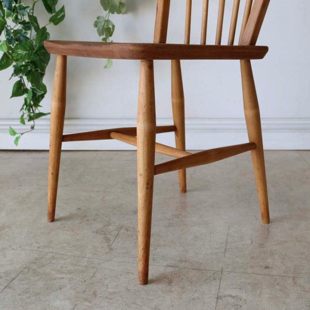 Mid-century British ERCOL Hoopback chair in natural teak with visible wood grain, rounded legs, and sleek, sturdy frame.