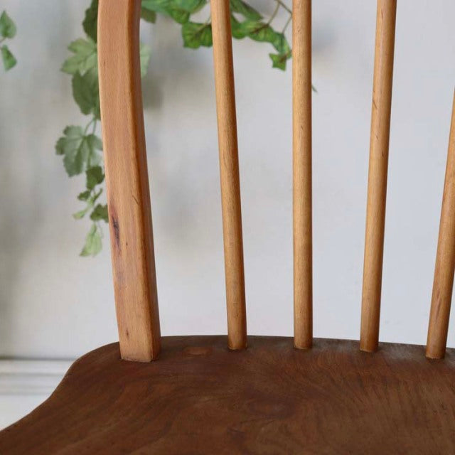 Vintage British mid-century Ercol dining chair in teak with smooth curved hoop back and vertical spindles showing natural.