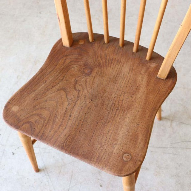 Vintage British mid-century Ercol dining chair in teak with contoured seat, visible wood grain, and spindle back legs from.