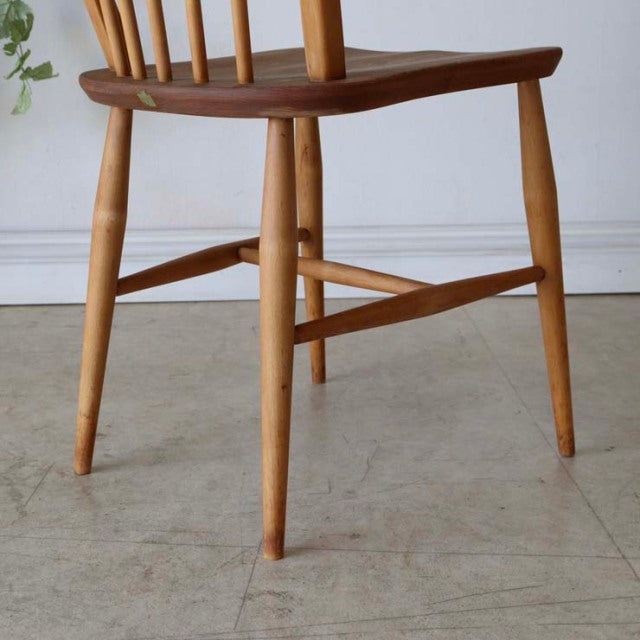 Vintage mid-century British Ercol hoop-back dining chair in teak with smooth wood grain and tapered legs.