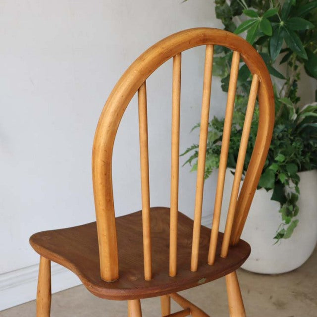 Vintage British Ercol mid-century teak dining chair with curved hoop back and vertical spindles.