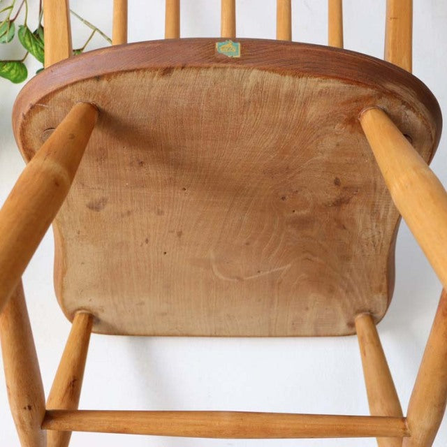 Vintage British mid-century teak Ercol hoop back dining chair viewed from underside showing wood grain and solid wood frame.