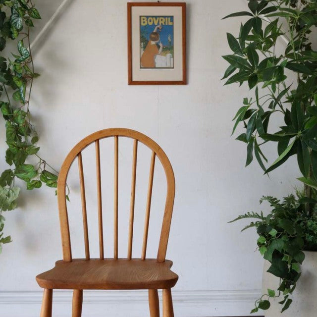 Vintage British mid-century Ercol hoop back chair in teak with curved spindled back and contoured seat, warm wood grain.