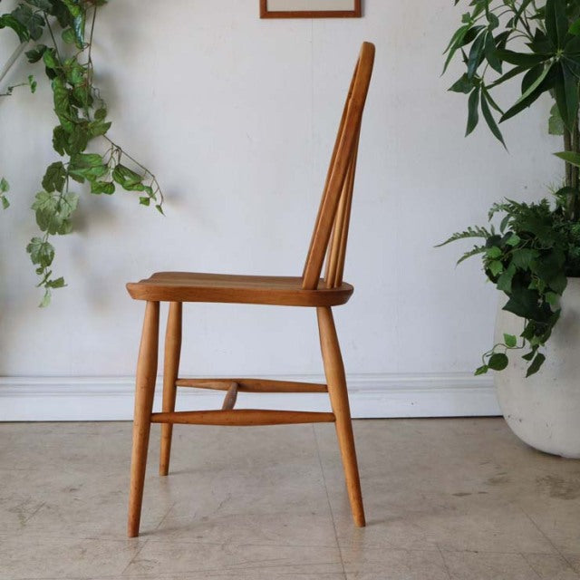 Vintage teak ERCOL mid-century British dining chair with hoop back, slender tapered legs, and visible wood grain.