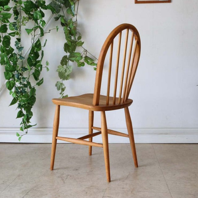 Vintage British mid-century Ercol dining chair in teak with curved hoop back and spindle slats, smooth wood grain finish,.