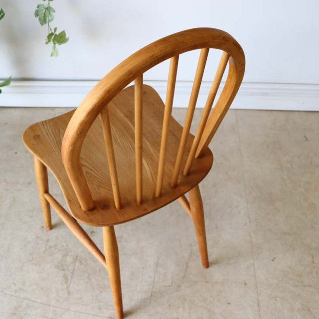 Vintage British mid-century Ercol teak dining chair with hoop back, smooth wood grain, and tapered legs.