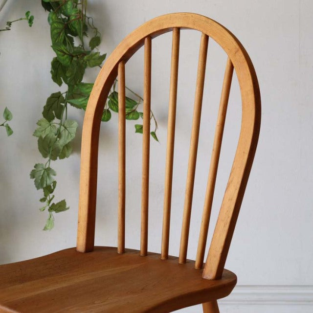Mid-century British vintage ERCOL Hoopback chair in natural teak with curved spindle back and smooth wood grain.