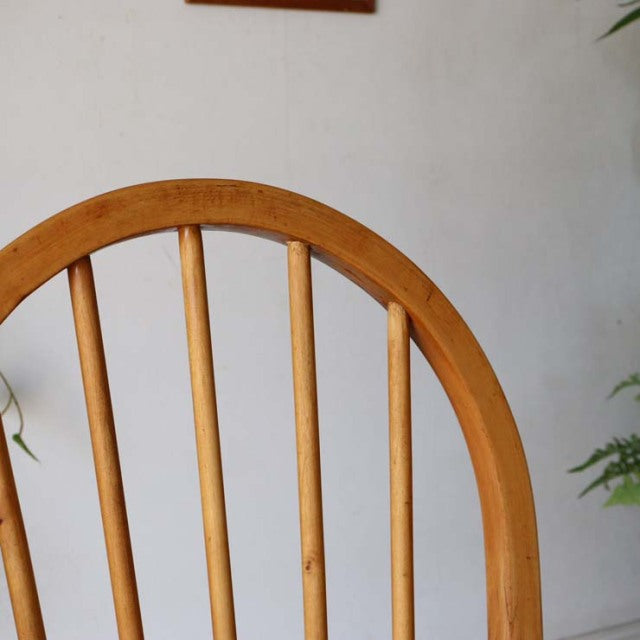 Mid-century British vintage Ercol hoop back dining chair in teak with smooth curved backrest and visible wood grain.