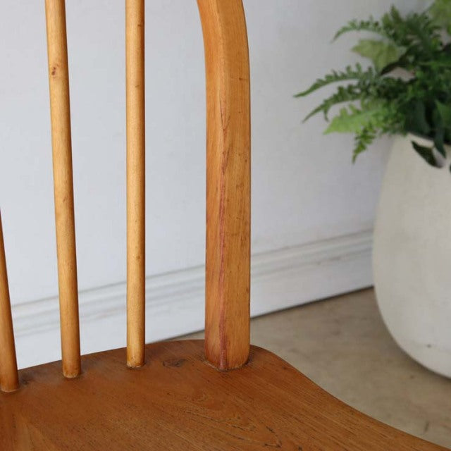Mid-century British vintage Ercol hoop back dining chair in teak with smooth curved spindles and visible wood grain.