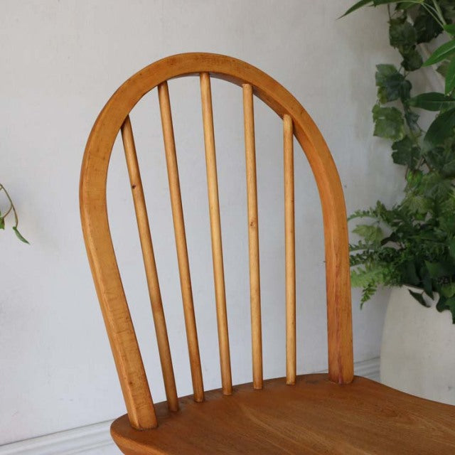 Vintage British mid-century Ercol hoop-back dining chair in warm teak with smooth curved spindles and rich wood grain.
