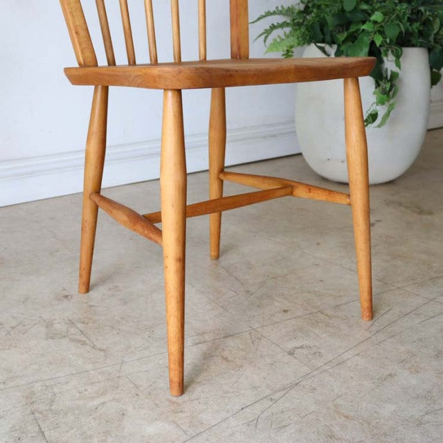 Mid-century British vintage teak Ercol hoop-back dining chair with tapered legs and visible wood grain.