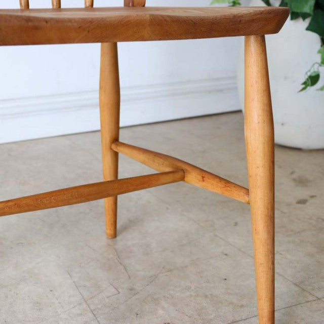 Mid-century British Ercol vintage teak dining chair with smooth wood grain and tapered legs.