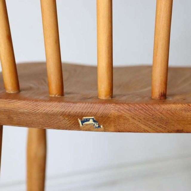 Close-up of vintage British ERCOL mid-century teak dining chair backrest showcasing natural wood grain and original label on .