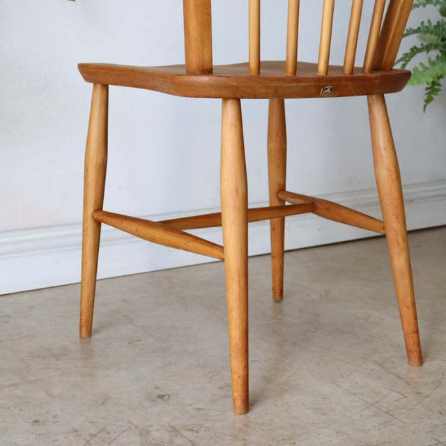 Vintage British Ercol hoop-back dining chair in teak with smooth wood grain, slender round legs, and mid-century design.