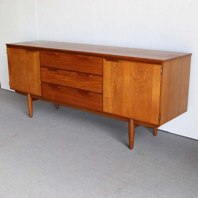 Vintage teak sideboard by Austinsuite, British mid-century design with smooth wood grain, three center drawers, two cabinet.