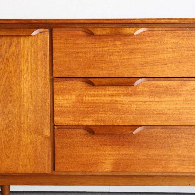 Vintage mid-century teak sideboard by Austinsuite, British design with smooth wood grain and curved handle cutouts on.