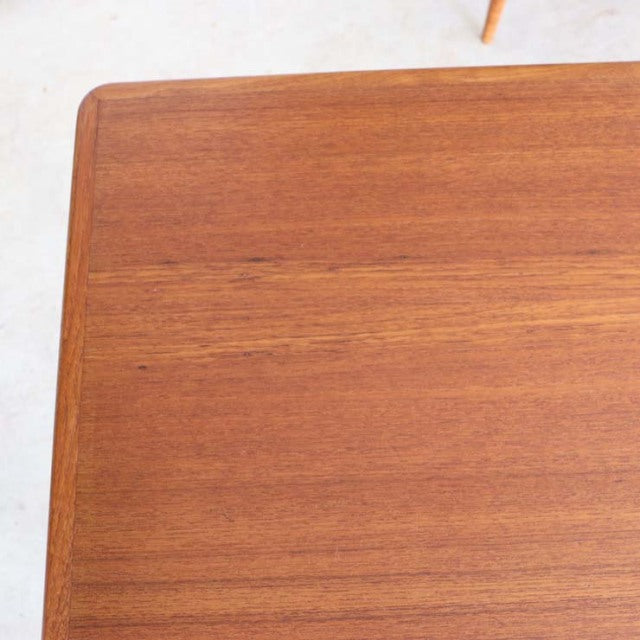 Mid-century Danish vintage teak dining table corner with smooth wood grain and rounded edges.
