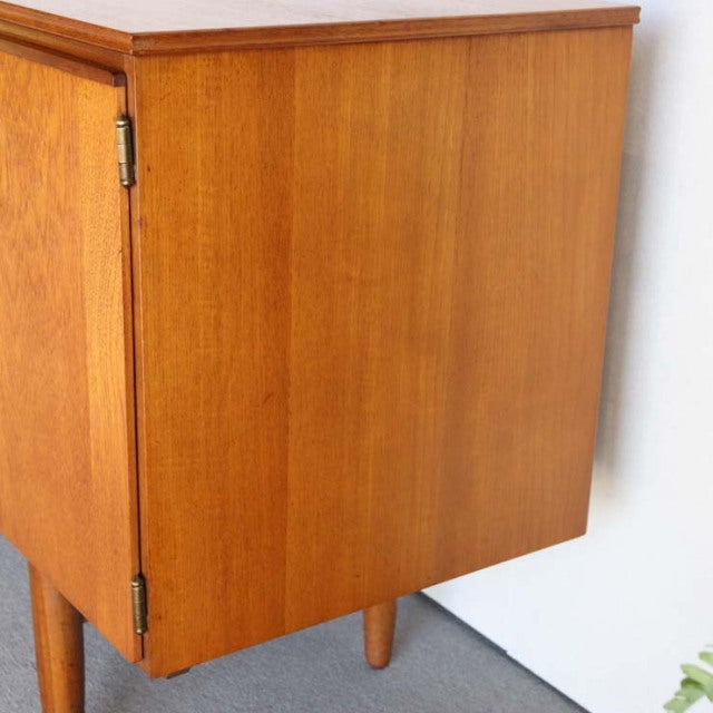 Vintage mid-century Austinsuite teak sideboard from Britain with smooth wood grain, rounded edges, and tapered legs in.