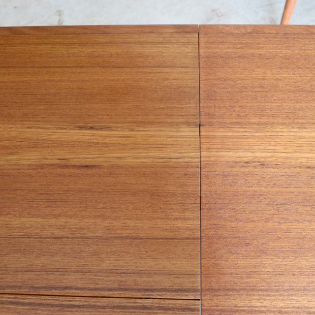 Vintage mid-century Danish dining table in teak with smooth rectangular top and visible wood grain detailing.