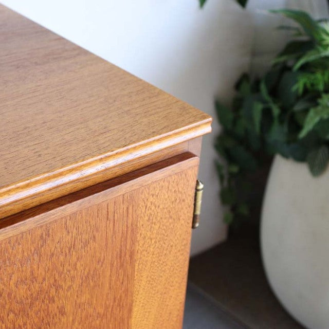 Vintage teak sideboard corner with smooth wood grain, British mid-century style, slender edges, and clean lines.