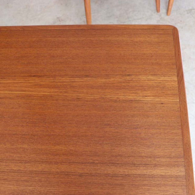 Vintage mid-century Danish teak dining table with rectangular top, smooth wood grain, and tapered legs.