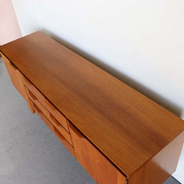 Mid-century vintage teak sideboard by Austinsuite with smooth wood grain and angled legs, British-Denmark design.