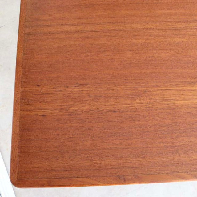 Mid-century vintage Danish teak dining table with smooth wood grain and rounded edges.