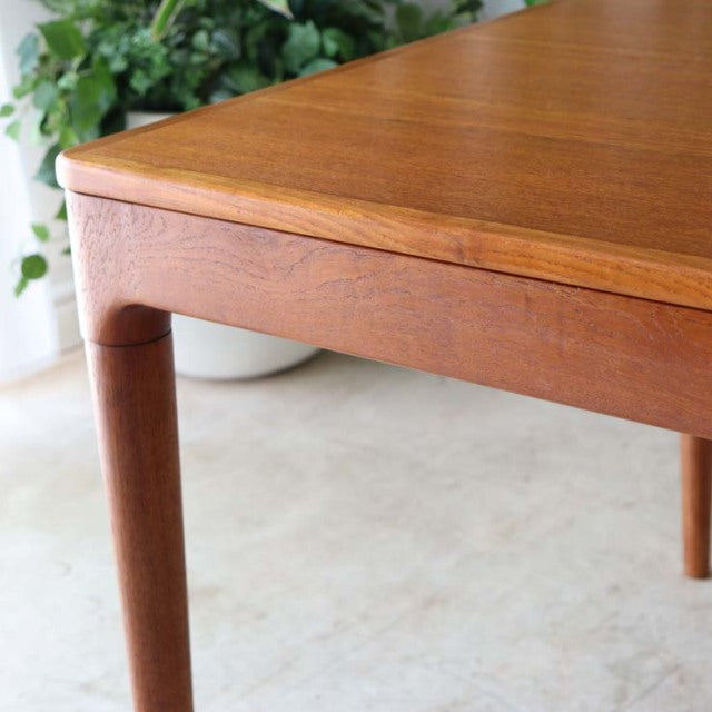 Mid-century vintage teak dining table from Denmark featuring smooth wood grain, rounded edges, and tapered legs.