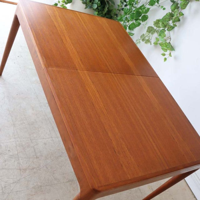 Vintage mid-century Danish teak dining table with rectangular top, smooth wood grain, and tapered legs.