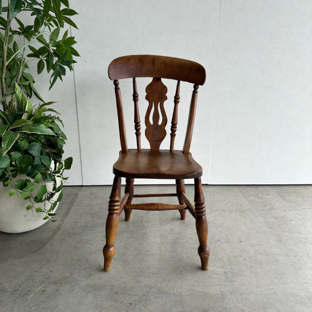 Vintage teak British mid-century kitchen chair with turned legs and decorative slat backrest.