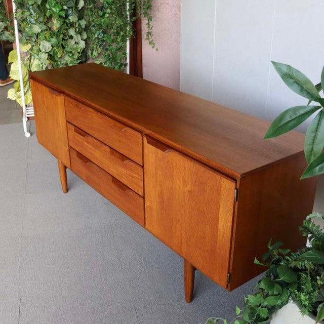 Mid-century vintage teak sideboard by Austinsuite with smooth wood grain, tapered legs, and clean British-Denmark inspired.