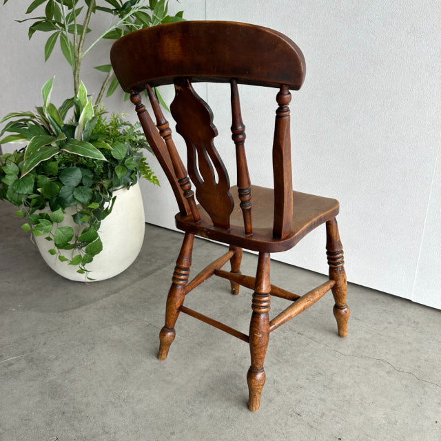 Vintage British mid-century teak kitchen chair with turned legs and curved spindle backrest.