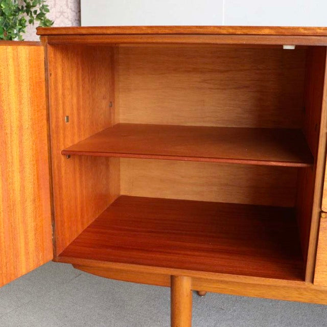 Mid-century British vintage teak sideboard interior with adjustable shelf and warm wood grain by Austinsuite, Denmark style.