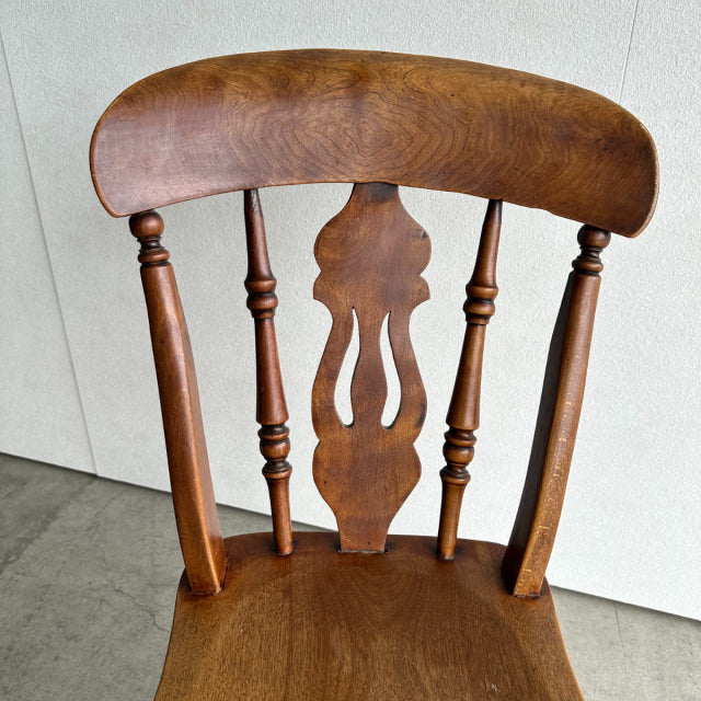 Vintage British teak kitchen chair with mid-century Denmark design, curved backrest and detailed spindle legs.
