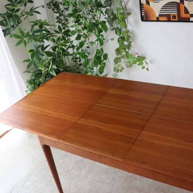 Mid-century Denmark vintage teak dining table with rich wood grain and tapered legs in pristine condition.
