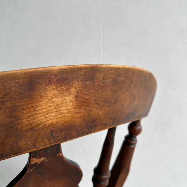 Vintage teak kitchen chair backrest with rich wood grain and turned British mid-century legs.