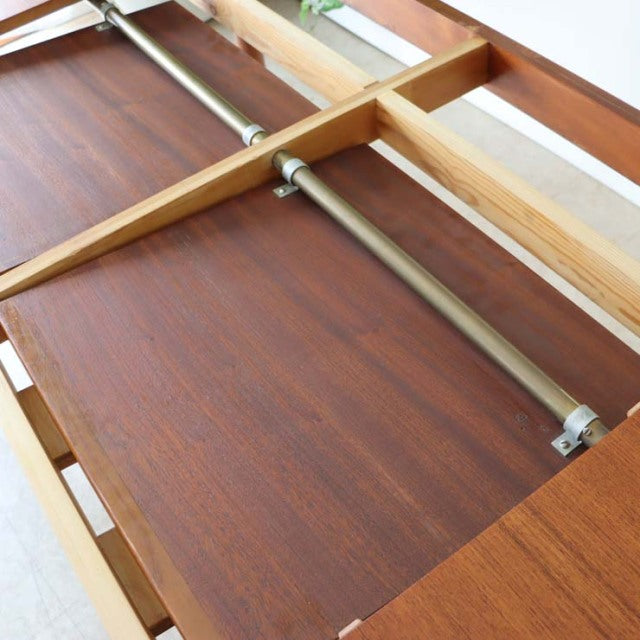 Mid-century vintage Danish teak dining table with visible wood grain and sturdy metal support bars under rectangular top.
