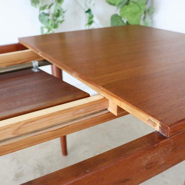 Mid-century vintage teak dining table from Denmark with rich wood grain and sleek tapered legs.