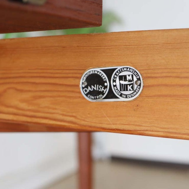 Close-up of teak wood grain and mid-century Danish label on vintage British dining table frame.