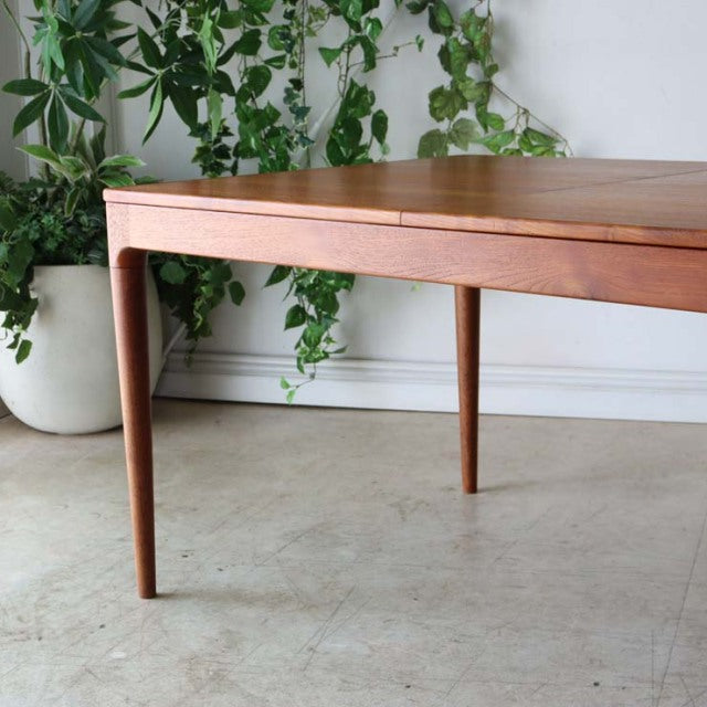 Mid-century vintage teak dining table from Denmark with tapered legs and visible wood grain.