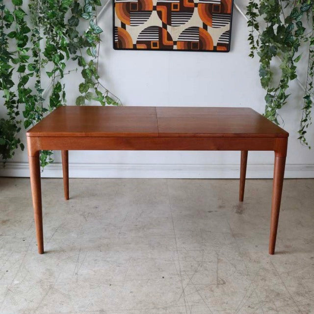 Mid-century vintage teak dining table from Denmark with rectangular top and slender tapered legs.