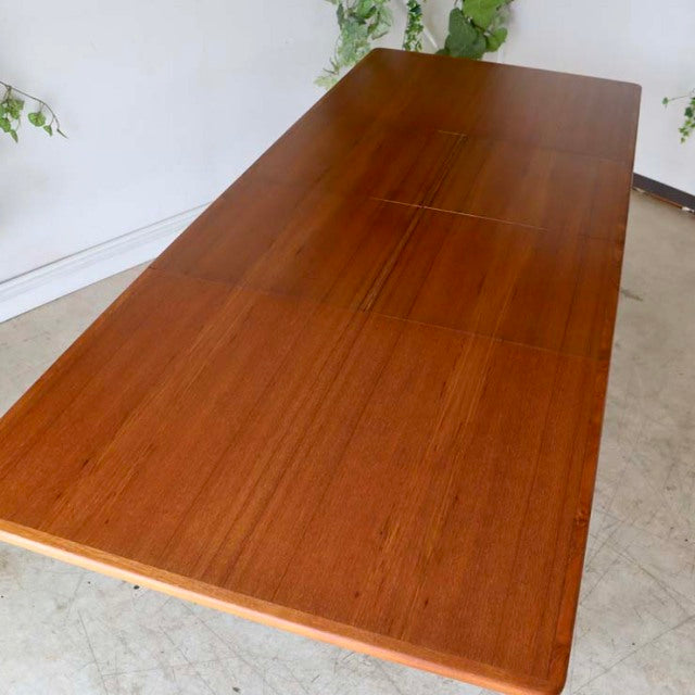 Mid-century vintage teak dining table from Denmark with rich wood grain and rectangular top.