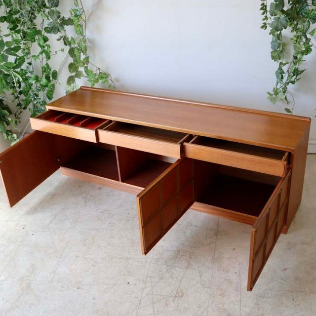 Vintage McIntosh teak sideboard with open drawers and cabinets, mid-century British-Denmark design, showcasing rich wood.