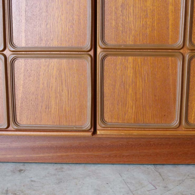 Close-up of vintage mid-century McIntosh teak sideboard doors with rich wood grain and rounded rectangular panel design.