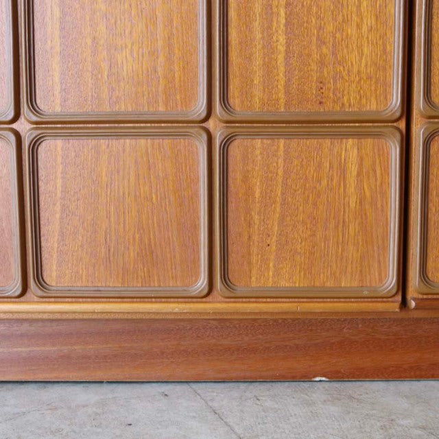 Close-up of vintage teak sideboard door panels with rounded edges and visible wood grain, mid-century British design from.