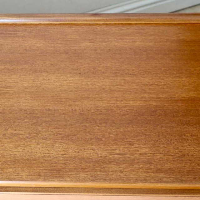 Smooth teak wood grain surface of vintage McIntosh mid-century British sideboard with warm honey tones.