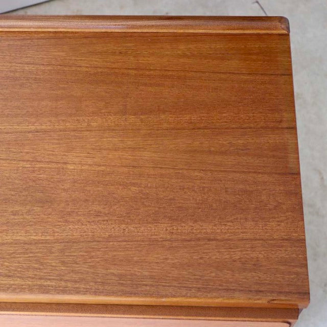 Mid-century British teak sideboard top with smooth grain and warm honey tones, vintage McIntosh design.