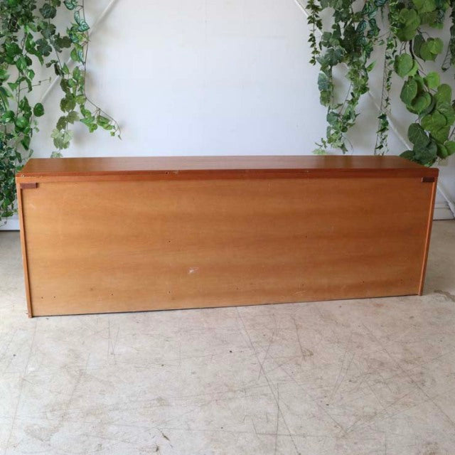 Vintage British mid-century teak sideboard with clean grain, sleek rectangular form, and slender legs, reflecting Danish.