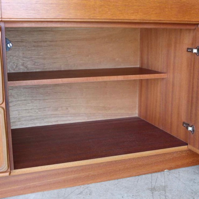 Vintage mid-century teak sideboard interior with smooth wood grain and adjustable shelf, British-Denmark design.