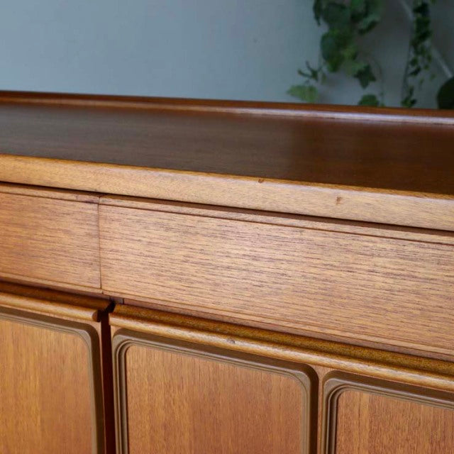 Mid-century vintage British teak sideboard by McIntosh with smooth wood grain and rectangular cabinet doors.